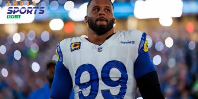 Los Angeles Rams defensive tackle Aaron Donald wearing a white and royal blue number 99 jersey on the football field under bright stadium lights.